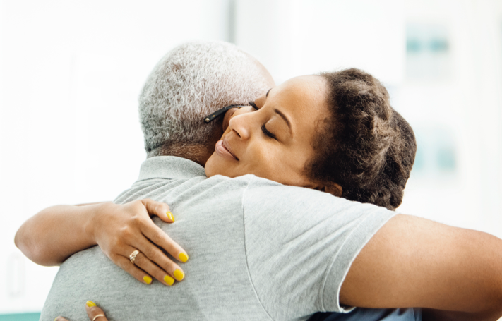 Photograph of a younger woman hugging an older man Photograph of a younger woman hugging an older man