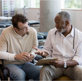  Photograph of a doctor talking to a younger man about information on his medical chart